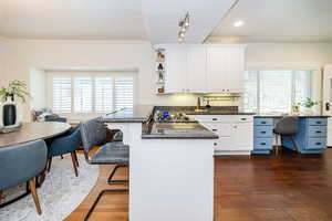 Kitchen and dining space with white-painted cherry cabinetry, granite countertops and breakfast bar