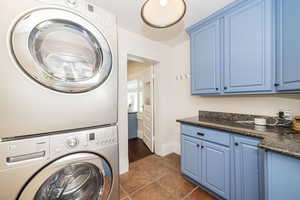 Laundry/Mud room at back of house showing included washer/dryer and cabinetry