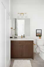 Bathroom featuring toilet, tile patterned floors, baseboards, and vanity