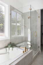 Full bathroom featuring a garden tub, tile patterned flooring, and a shower stall