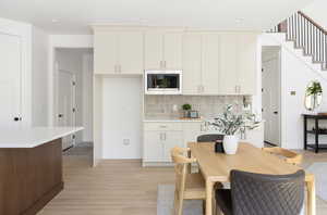 Kitchen featuring light countertops, stainless steel microwave, and light wood-style flooring