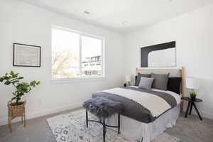 Bedroom featuring baseboards, visible vents, and light colored carpet