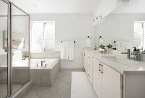 Bathroom with double vanity, an enclosed shower, a bath, tile patterned floors, and a sink