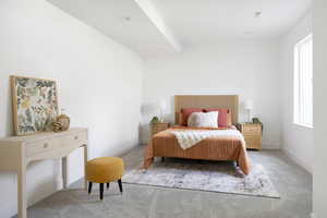 Carpeted bedroom featuring baseboards and visible vents