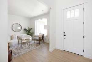 Entryway with baseboards and light wood finished floors