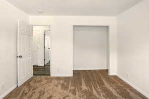 Unfurnished bedroom featuring carpet flooring and baseboards