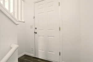 Doorway to outside with baseboards and dark wood finished floors