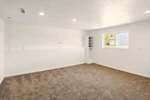 Spare room with carpet floors, recessed lighting, baseboards, and visible vents