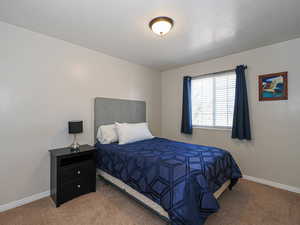 Bedroom featuring baseboards and carpet