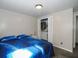 Carpeted bedroom featuring baseboards and a closet