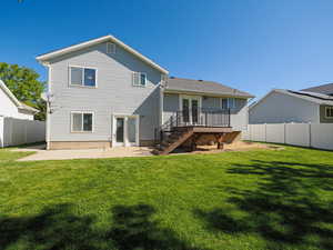 Rear view of property featuring a wooden deck, a fenced backyard, a patio area, a yard, and stairway