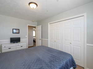 Bedroom featuring a textured ceiling and a closet