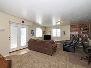 Living area featuring baseboards, a textured ceiling, and visible vents