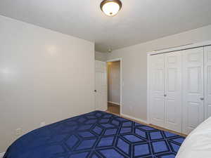 Unfurnished bedroom with a textured ceiling, baseboards, and a closet
