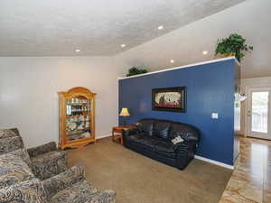 Carpeted living room with baseboards, recessed lighting, a textured ceiling, and lofted ceiling
