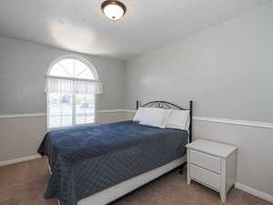 Bedroom featuring carpet flooring and baseboards