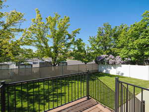Wooden deck featuring a fenced backyard and a yard