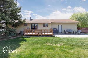 Back of property featuring a lawn, a deck, french doors, and a patio area