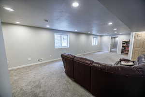 Living area with recessed lighting, visible vents, and carpet