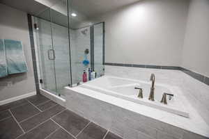 Full bath with a garden tub, tile patterned floors, and a shower stall