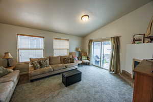 Living area featuring carpet floors and lofted ceiling