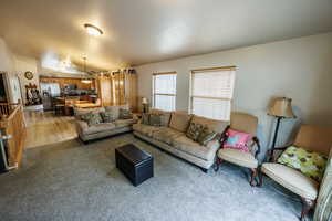 Living room with light carpet and lofted ceiling