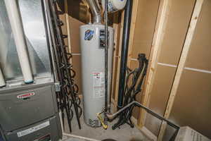 Utility room featuring heating unit and water heater