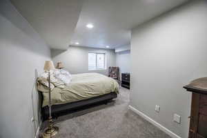Carpeted bedroom featuring recessed lighting, a textured ceiling, and baseboards