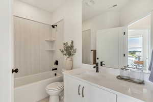 Bathroom with vanity, toilet, tile patterned floors, shower / bathing tub combination, and visible vents