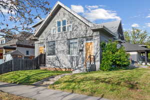 Bungalow-style house with a front lawn and fence