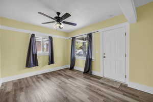 Empty room with baseboards, wood finished floors, a wealth of natural light, and visible vents