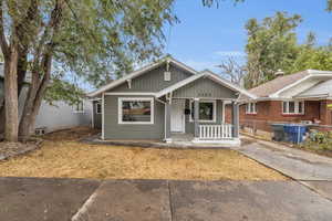 Bungalow featuring a porch, board and batten siding, and fence