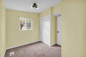 Unfurnished bedroom featuring visible vents, carpet flooring, baseboards, and a closet