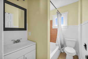 Full bath featuring toilet, shower / bathtub combination with curtain, tile patterned flooring, and vanity