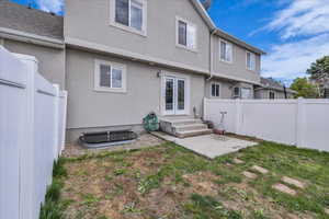 Back of property featuring a fenced backyard, a patio, and stucco siding