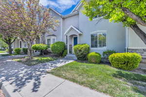 View of front of home featuring stucco siding, a front lawn, and stone siding