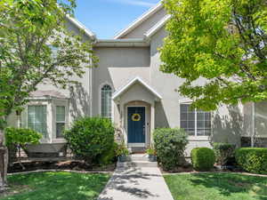 Doorway to property featuring a lawn and stucco siding