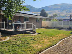 Fenced backyard with a deck with mountain view
