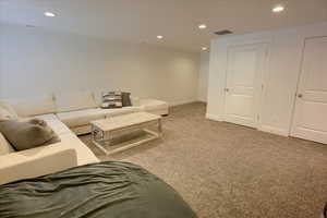 Living area featuring visible vents, recessed lighting, carpet, and baseboards