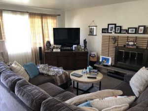 Carpeted living room with a brick fireplace
