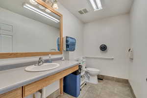 Bathroom with visible vents, toilet, baseboards, tile patterned floors, and a sink