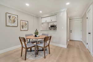 Dining area featuring recessed lighting, baseboards, ornamental molding, and light wood-type flooring