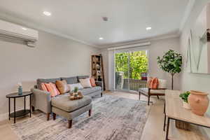Living area featuring crown molding, recessed lighting, wood finished floors, and a wall mounted air conditioner