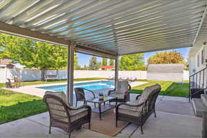 View of patio with a fenced in pool, a fenced backyard, an outdoor living space, and an outdoor structure