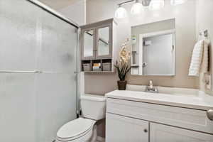 Full bathroom featuring an enclosed shower, toilet, and vanity