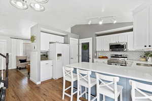 Kitchen featuring quartz countertops, stainless steel appliances, a peninsula, and tasteful backsplash