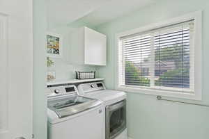 Laundry room with laundry area, washer and clothes dryer, and a wealth of natural light