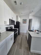 Kitchen featuring visible vents, a sink, appliances with stainless steel finishes, and wood finished floors