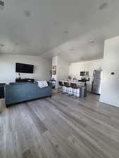 Living area with baseboards, visible vents, and wood finished floors