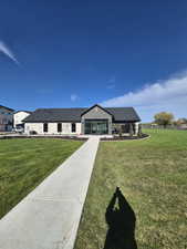 View of front of house featuring roof with shingles and a front lawn